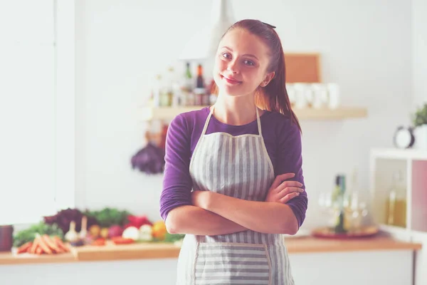 Jovem mulher de pé em sua cozinha perto da mesa. Jovem mulher na cozinha — Fotografia de Stock