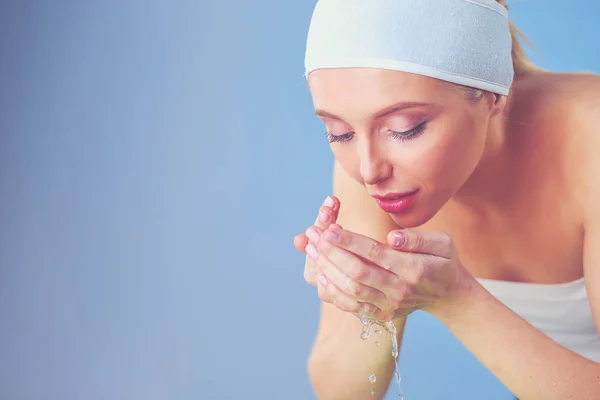 Young female washing her face with clear water. Young female .