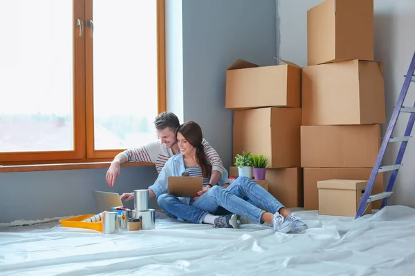 Jong koppel zittend op de vloer van hun nieuwe appartement. Jong koppel — Stockfoto