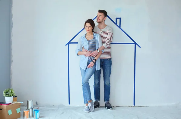 Couple standing in front of painted home on wall. Young couple — Stock Photo, Image