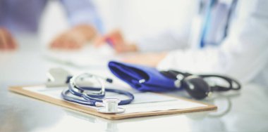 Doktor kadın, masasında erkek hastayla oturuyor.