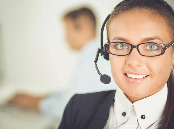 Gelukkig vrouwtje draagt een headset en zit op het bureau — Stockfoto