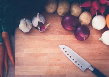 Mutfaktaki masanın üstünde sebzeler var.