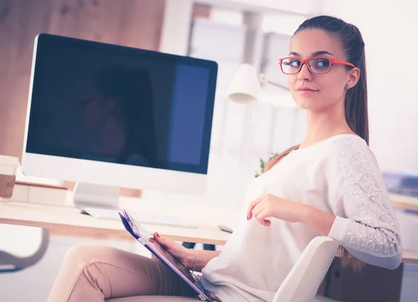 Modedesigner arbeiten im Atelier und sitzen auf dem Schreibtisch — Stockfoto