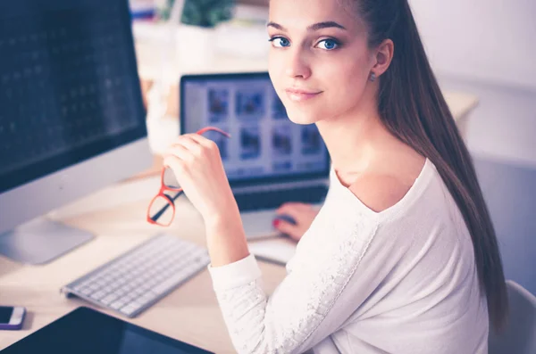 Portret van een aantrekkelijke jonge zakenvrouw zittend achter een computer. — Stockfoto
