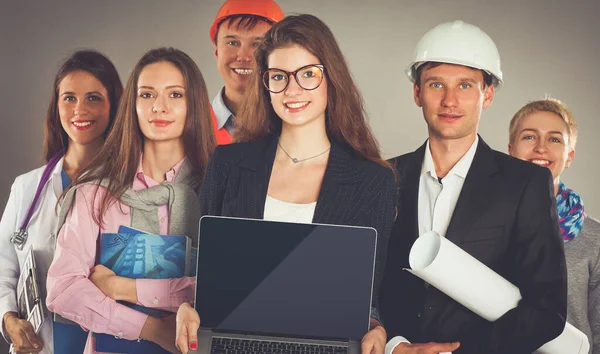 Leende affärskvinna med bärbar dator och grupp av industriarbetare — Stockfoto