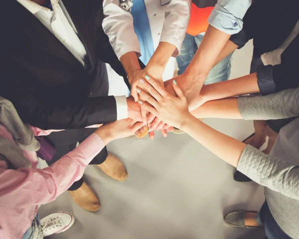 Portrait of people with various occupations putting their hands on top of each other — Stock Photo, Image