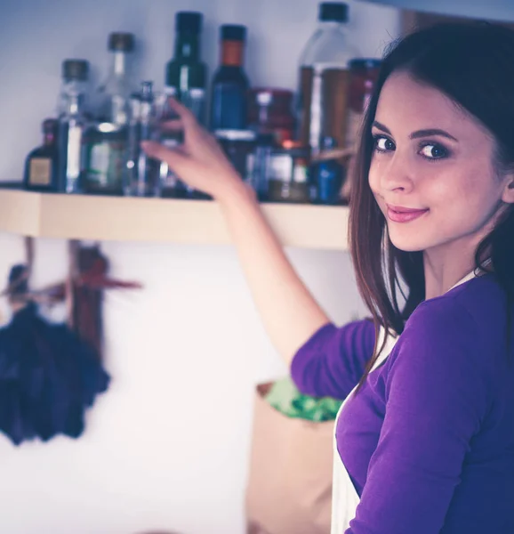 Una giovane donna che sceglie spezie nella sua cucina . — Foto Stock