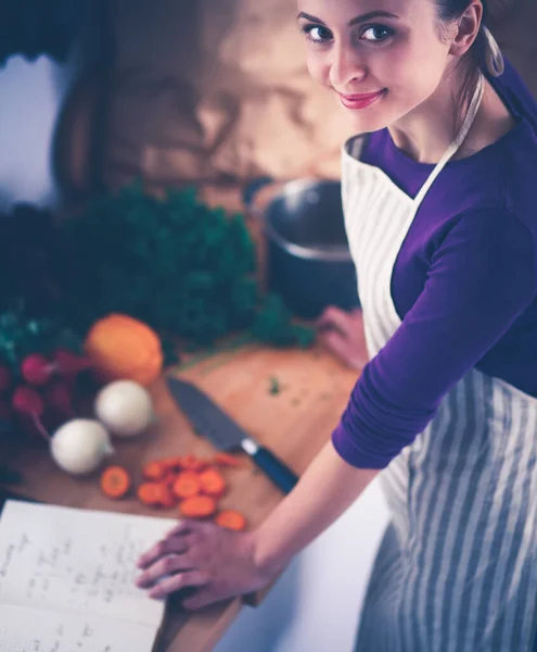 Νεαρή γυναίκα κόβει λαχανικά στην κουζίνα — Φωτογραφία Αρχείου