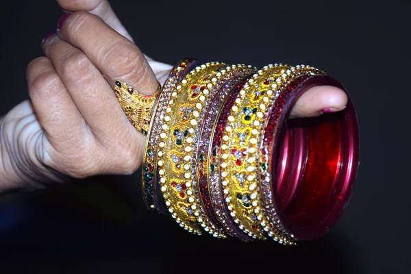 Indische Frauenhand, die Armreifen mit schwarzem Hintergrund hält, — Stockfoto