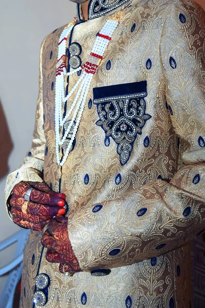 Strong handsome Indian groom holds his hands over wedding suit — Stock Photo, Image