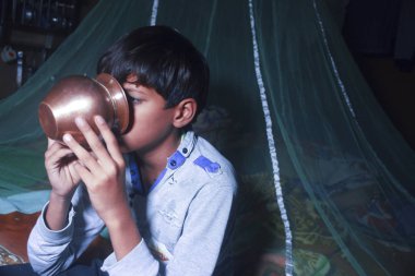 Sabahları bakır tencereden su içen bir çocuk.