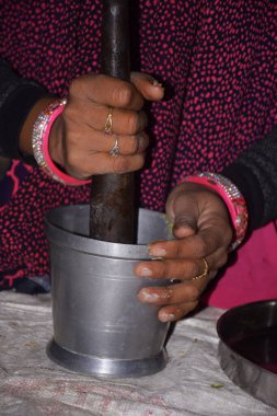 Hintli kırsal kadın sebze yapmak için baharat öğütüyor..