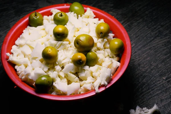 Böğürtlen ve doğranmış karnabahar sebze ve salata için kullanılan kırmızı renkli bir sepette tutulur.