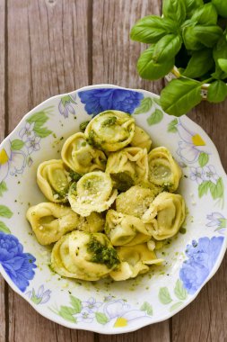 Ev yapımı vejetaryen İtalyan biyo-yumurtası taze tortelloni makarna zeytin yağı ve parmesan peyniri ile süslenmiş peynir için.
