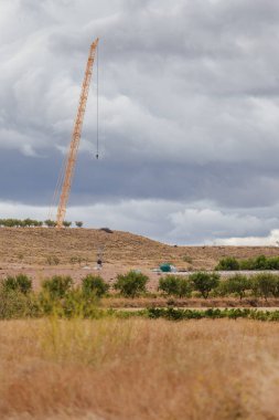 Tarlanın ortasına rüzgar türbini inşa etmek için vinç.