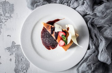 Beyaz arka planda tabakta çilekli peynirli kek