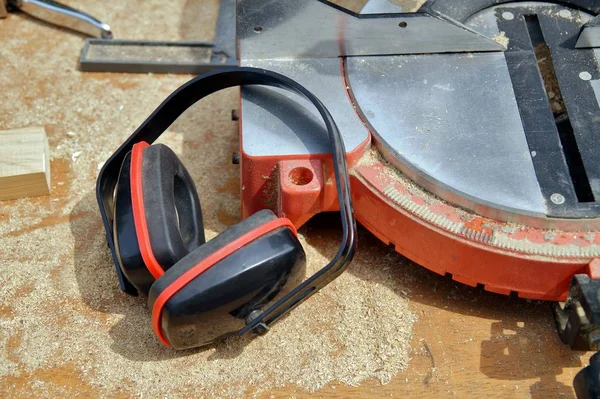 Ear Defenders lying on working table next to a chop saw