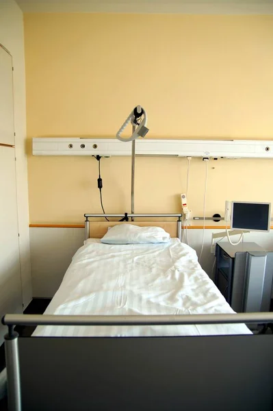 Bedroom for patient in a hospital. Yellow room design. Mattress with white cloth. Bedroom for patient in a hospital. Hospital bed, patient bed, Hospital equipment, clean but old, health concept