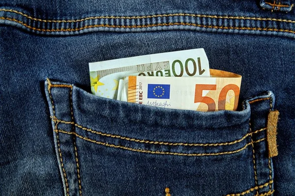 euro money cash, euro banknotes in the pockets of jeans trousers.banner for web, gift card, postcard. Concept of wealth, saving or spending money. Euro bills falling out. Easy to steal the money.