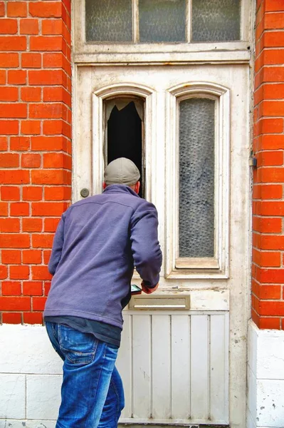 person standing outside of house, curious Man is peeking into the house through the window of an old doors. Curiosity of a male spy