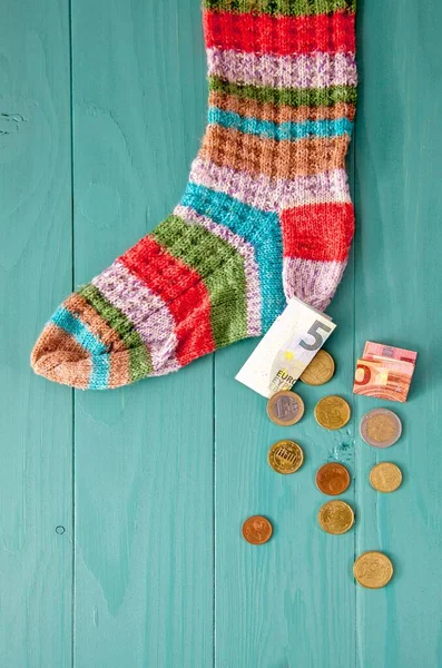 euro money in the sock. retirement savings and hiding concept. depositing money in a sock. Saving sock. Coins Spill From Wool Sock