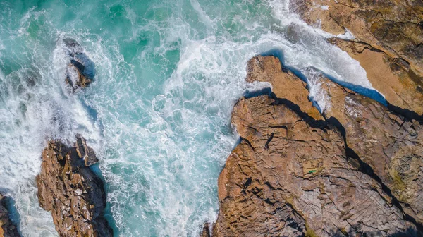 无人驾驶飞机拍摄的在白天用翡翠颜色水岩石岬 免版税图库照片