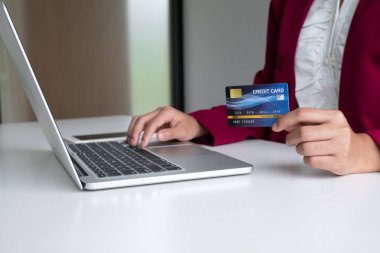 Online alışveriş ve ödeme için kredi kartı ve taptop tutan iş kadını tüketici Internet üzerinden bir satın alma yapmak