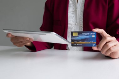 Online alışveriş ve ödeme için kredi kartı ve tablet tutan iş kadını tüketici Internet üzerinde bir satın alma yapmak