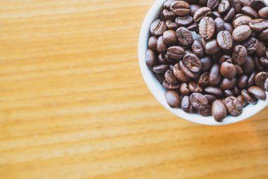Fincandan kavrulmuş kahve çekirdekleri, tazelik vermeye hazır ve işadamları yanında