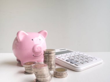Pembe Piggy banka ve para yığını ile hesap makinesi, gelecek planı ve emeklilik fonu kavramı için para tasarrufu