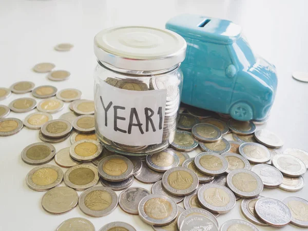 Glass Piggy bank and car bank with coins pile saving money in year one, Saving money for future plan and retirement fund concept — Stock Photo, Image