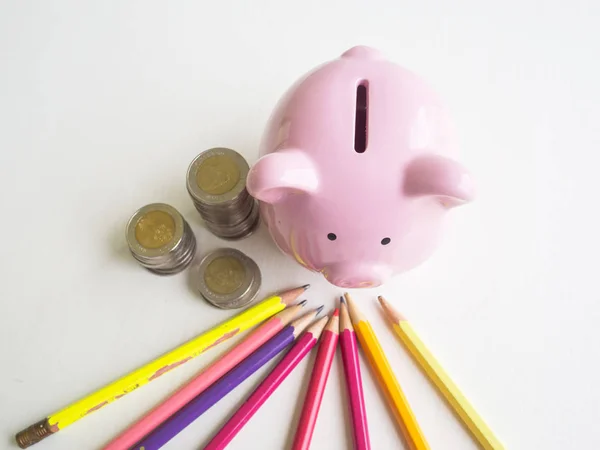 Piggy bank rosa com pilha de moedas e lápis coloridos brilhantes, economizando dinheiro para o futuro plano e conceito de fundo de aposentadoria — Fotografia de Stock