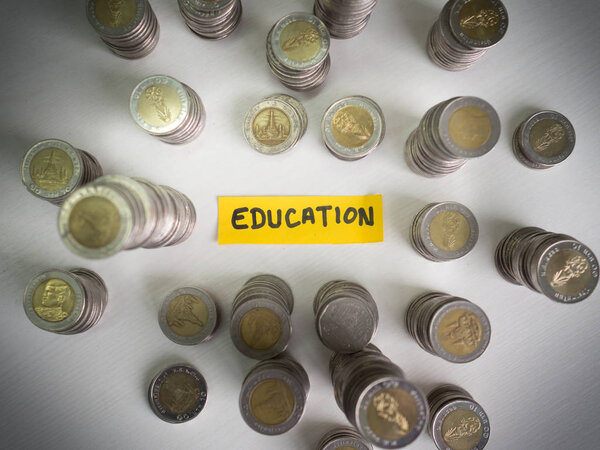 Желтая бумага для образования и куча монет, накопление денег на будущий план и концепцию пенсионного фонда
