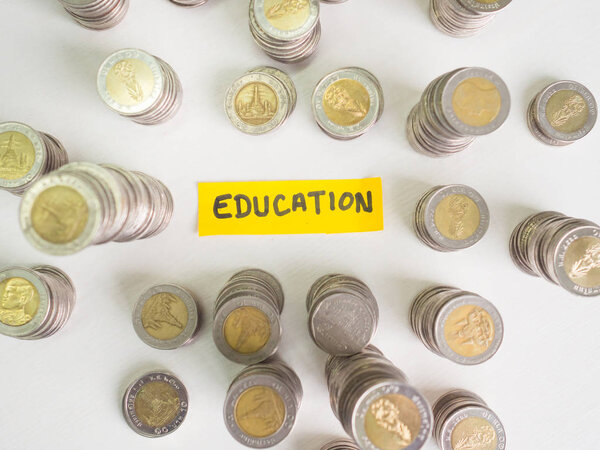 Желтая бумага для образования и куча монет, накопление денег на будущий план и концепцию пенсионного фонда
