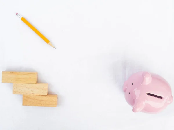 Růžová prasátka na bílém pozadí s dřevěnou a žlutou tužkou, kreslením vlastního způsobu úspory peněz pro budoucí koncept plánu a důchodového fondu — Stock fotografie