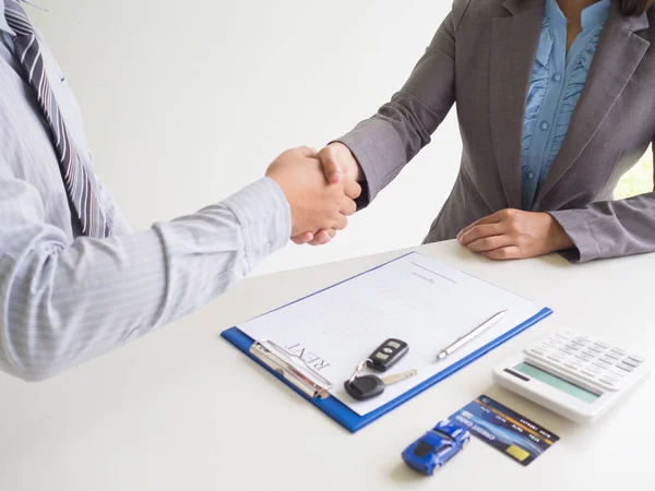 Customer woman used credit card and signed for rent car form salesman, Shake hands deal business