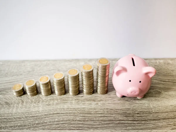 Piggy bank rosa com gráfico de crescimento de pilha de moedas, economizando dinheiro para o futuro plano de investimento e conceito de fundo de aposentadoria — Fotografia de Stock