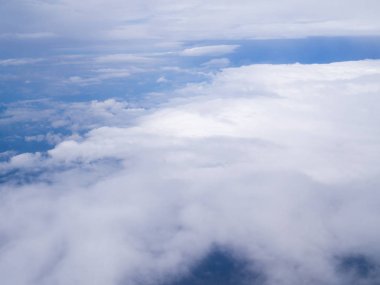 Mavi gökyüzü olan uçak penceresinden bulutlar