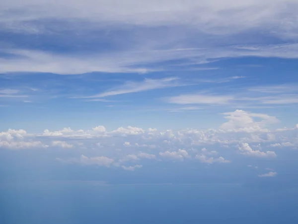 Nuages de la fenêtre de l'avion avec ciel bleu et sol à angle élevé — Photo