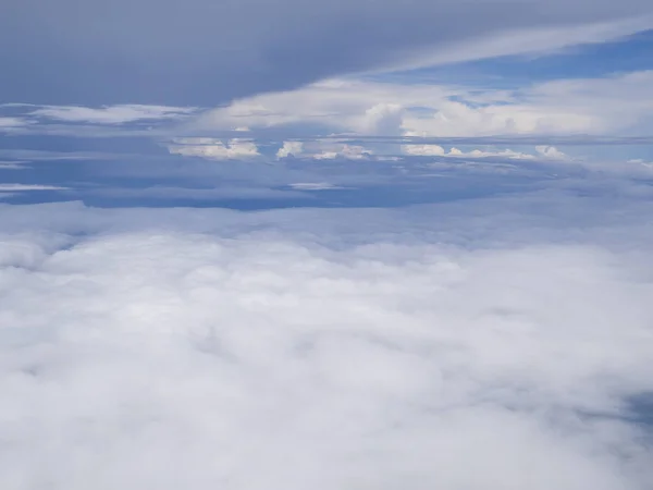 푸른 하늘을 배경으로 비행기 창문에서 날아온 구름 — 스톡 사진