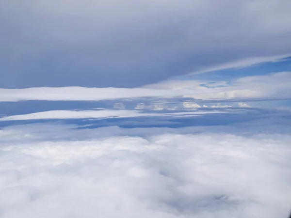 푸른 하늘을 배경으로 비행기 창문에서 날아온 구름 — 스톡 사진