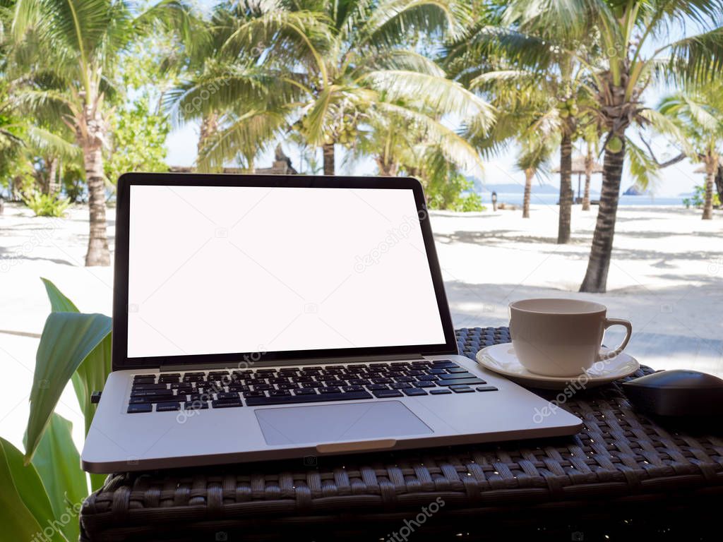 A cup of coffee beside laptop with Coconut tree and sea view, white sand beach background, Travel plans after retirement of business people