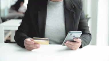 İş kadını tüketicisi, çevrimiçi alışveriş için kredi kartı ve akıllı telefon ile harcama yapıyor.