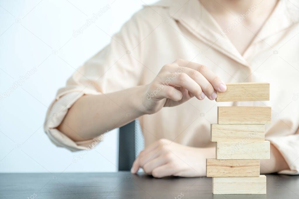 Hand holding blocks wood game, Concept Risk of management and strategy plan, growth business success process and team work.