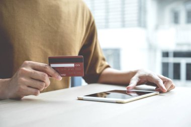 İş adamının elinde evden alınan bilgisayar tabletinden online alışveriş için kredi kartı, ödeme e-ticaret, internet bankacılığı, harcama parası.