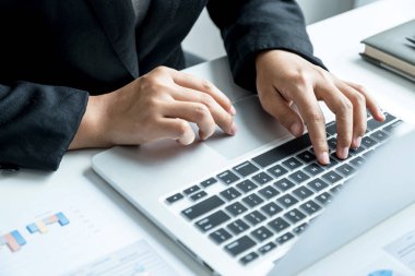 İş kadını, iş hedeflerini belirlemek ve yeni hedefe ulaşmayı planlamak için ofisteki grafiği bilgisayarla analiz ediyor..