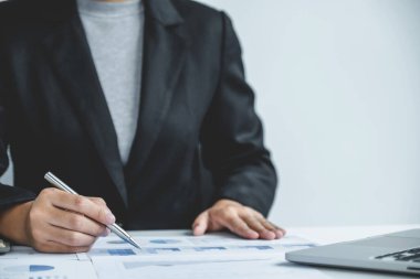 İş kadını el çabukluğu grafiği ve analizi ofisteki bilgisayarla iş hedefleri belirlemek ve yeni hedefe ulaşmayı planlamak için yapıyor..