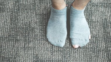 Eski, kirli ve yırtık çoraplar giyen bir çift ayak..