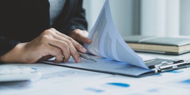 İş kadını, iş hedeflerini belirlemek ve yeni hedefe ulaşmayı planlamak için ofisteki grafiği bilgisayarla analiz ediyor..